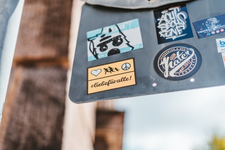 Stickers on a weathered metal surface, featuring various designs including phrases and logos, relating to enhanced cleaning techniques.