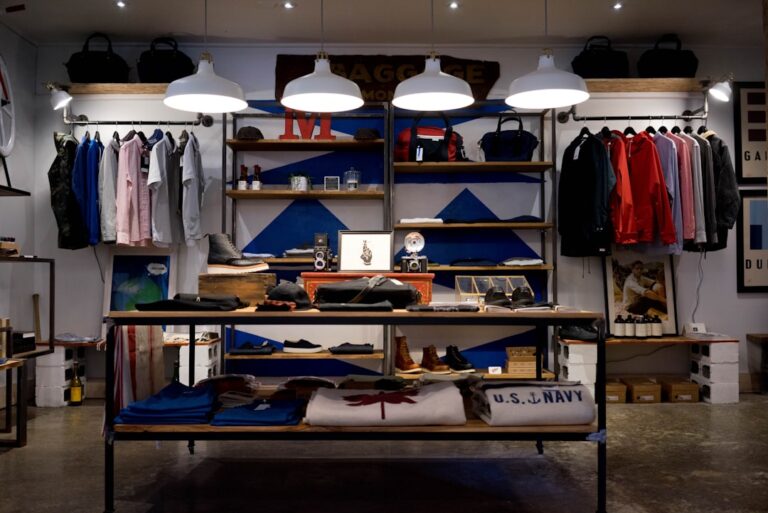 Clothing store with neatly arranged shirts, jackets, and accessories under well-lit shelves, exemplifying effective retail cleaning and display.