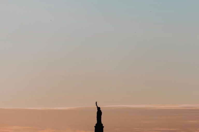 Silhouette of the Statue of Liberty at sunrise, symbolizing New York, aligning with the article about professional cleaning services in the city.