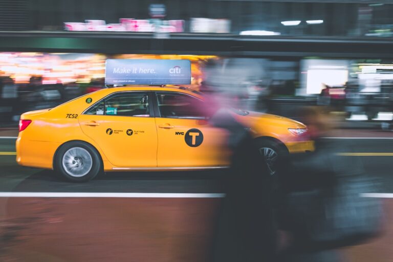 A New York City yellow taxi speeds through a busy street, illustrating the fast-paced life that makes hiring professional cleaning services essential.